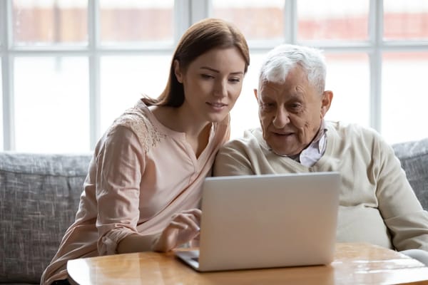Resident and staff member engaged with a laptop
