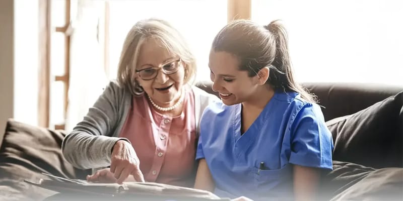 Caregiver and elderly resident smiling together