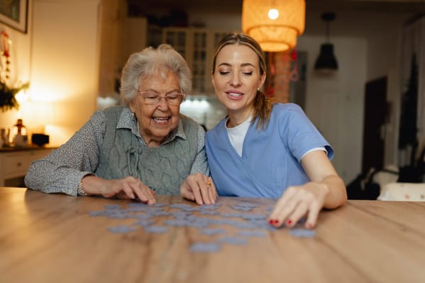Staff and resident enjoying a puzzle together