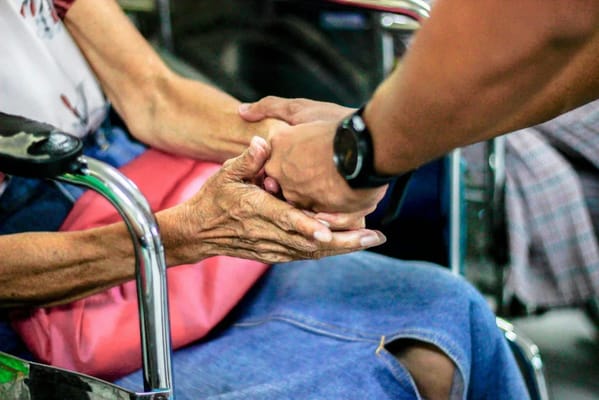 Hands of a caregiver and a senior resident in shared moment