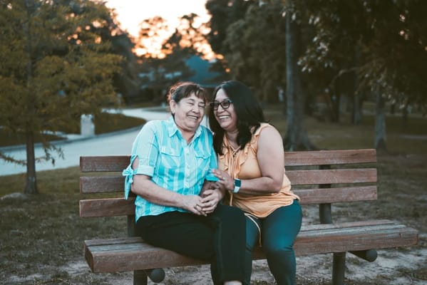 Two women enjoying conversation on a park bench