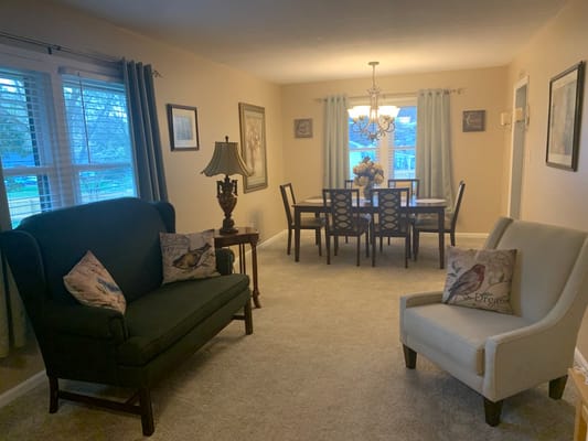 Living room with seating area and dining table in a senior living facility