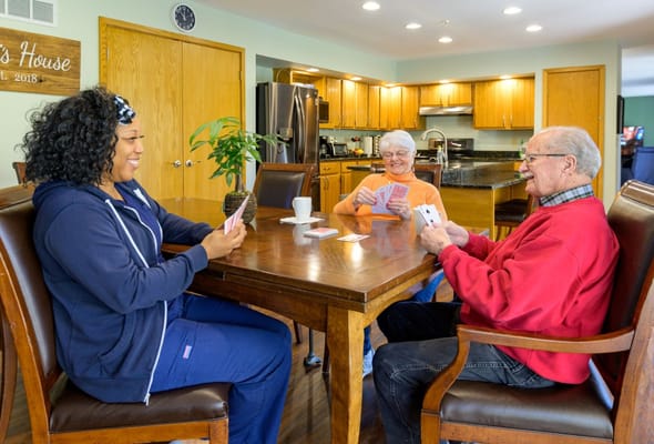 Residents and staff playing cards in a common area