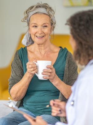 Senior resident enjoying a beverage during a conversation