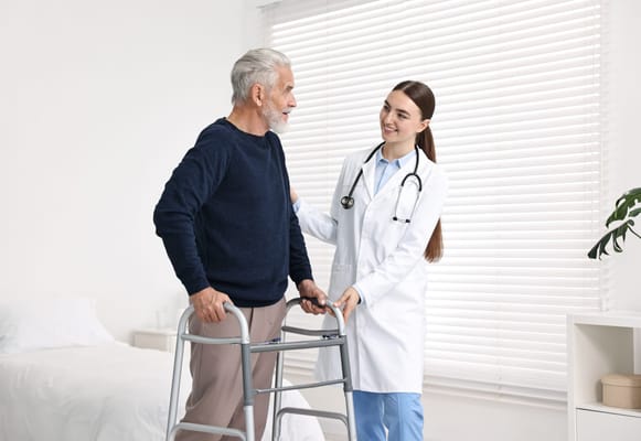 Staff assisting a resident with a walker in a room