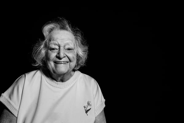 Smiling elderly woman with curly hair in a bright shirt