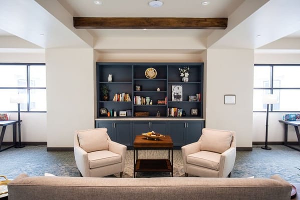 Cozy common area with armchairs and bookshelves