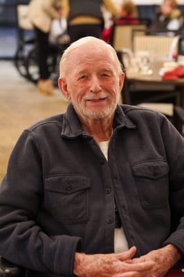 Resident smiling in a lively common area