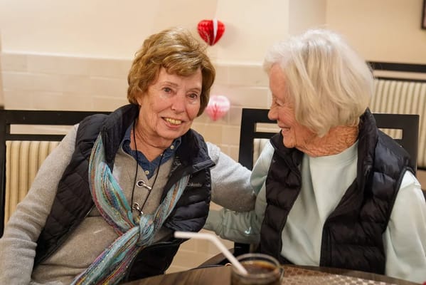Two residents enjoying conversation in a common area