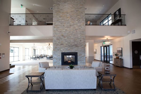 Bright lobby area with seating and stone fireplace