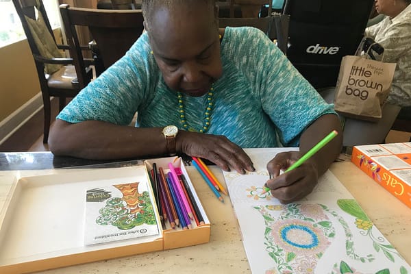 A resident coloring in an activity room