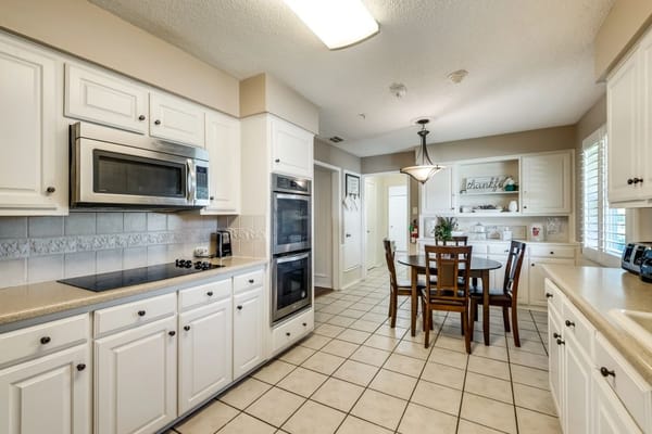 Bright kitchen area with dining table and appliances