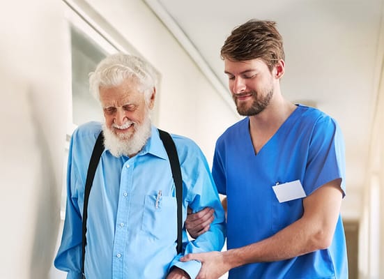 A caregiver assisting an elder resident in a hallway