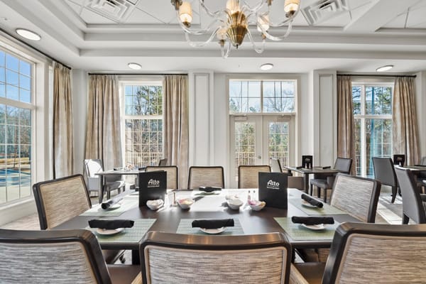 Bright dining room with large windows and elegant decor