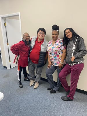 Staff members posing in a facility hallway