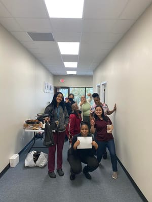 Staff and residents celebrating in a bright hallway