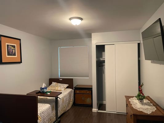 A cozy bedroom featuring a bed, bedside table, and closet.