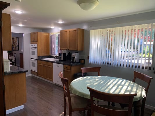 Bright kitchen with wooden cabinets and a dining table.