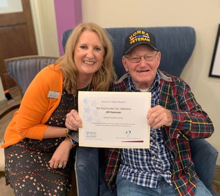 Staff member with a veteran resident holding an appreciation certificate