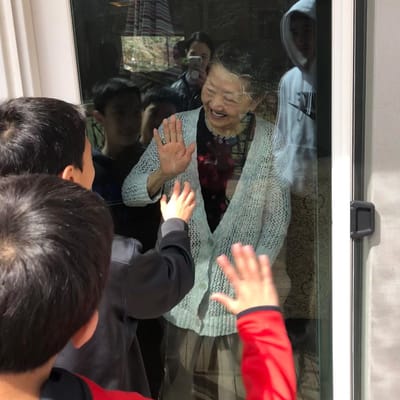 Residents and children sharing a joyful moment through the window