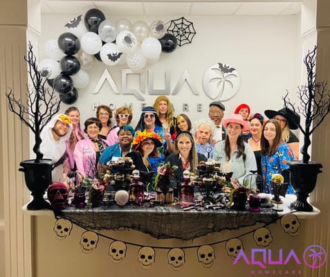 Residents and staff in colorful costumes at a Halloween celebration