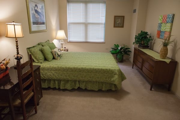 Cozy resident room with a green bedspread and furnishings
