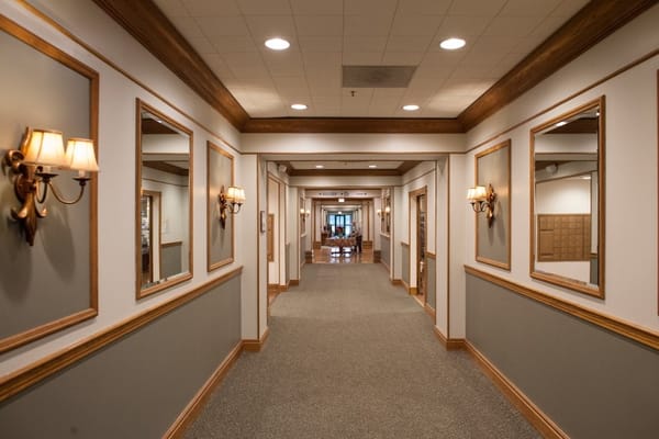 Brightly lit hallway with sconces and mirrors