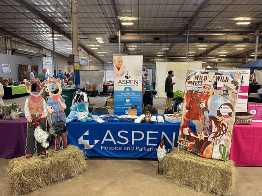 Booth display of Aspen Hospice with cowboy-themed decorations and cutouts