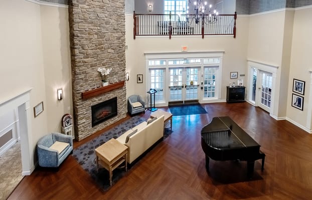 Spacious lobby featuring a stone fireplace and piano