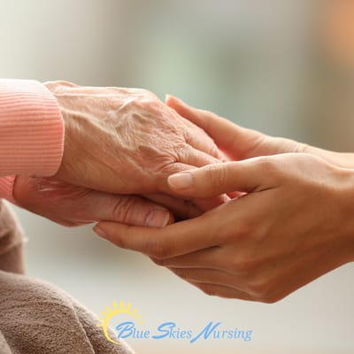 A caregiver holding a senior person's hand