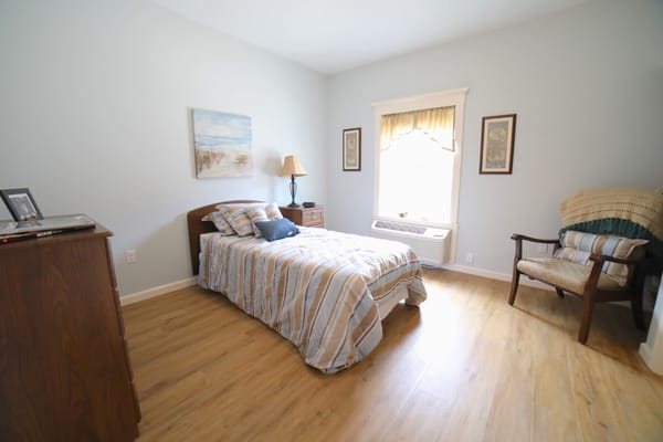 Cozy private resident room with a bed and chair