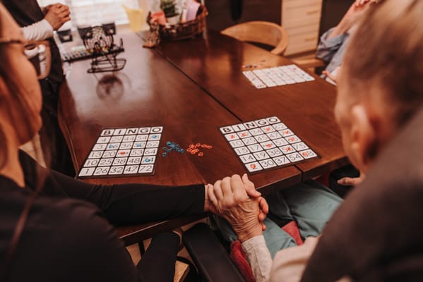 Residents participating in a bingo game at a wooden table
