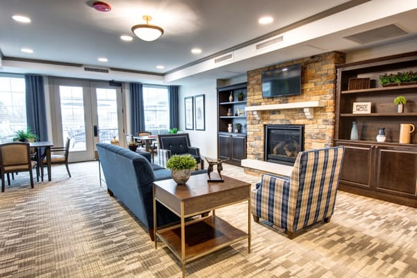 A cozy lounge with seating, coffee table, and fireplace.