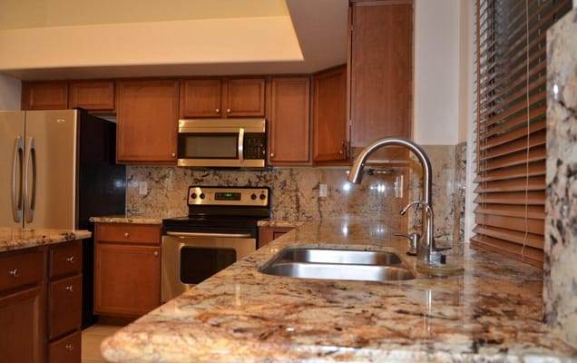 Spacious kitchen with granite countertops and stainless steel appliances.