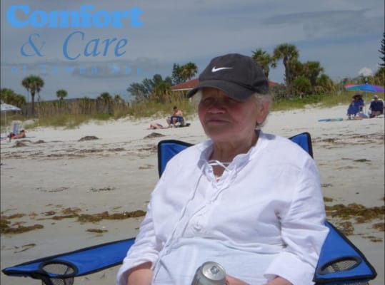 Woman sitting on the beach with logo overlay