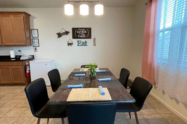 A dining table set with blue napkins in Dayflower Care Home.