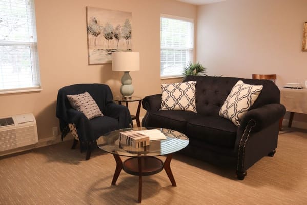 Comfortable living room with a couch, coffee table, and lamp.