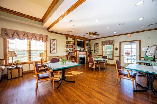 Interior view of the common room with tables and chairs at Doverwood Skilled Nursing Facility