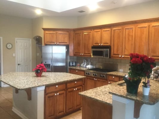 A kitchen with wooden cabinets and granite countertops