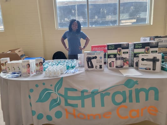 A staff member at a promotional event with products displayed