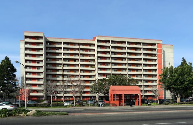 Front view of Flower Park Plaza, a multi-story senior living facility.