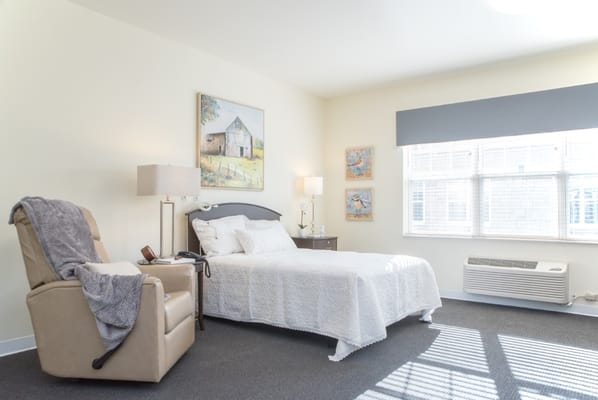 Bright bedroom featuring a bed and a recliner chair