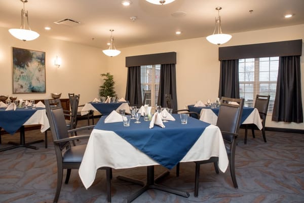 Dining room setup with tables and blue tablecloths