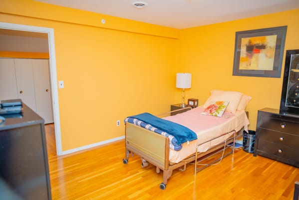 A cozy resident room with warm colors and wooden flooring