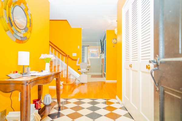 Brightly colored entryway with a staircase and seating