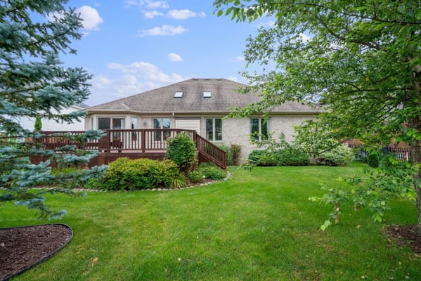 View of the backyard at Hearthstone Communities with green lawn and deck.