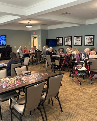 Seniors enjoying a puzzle activity in a cozy common area.