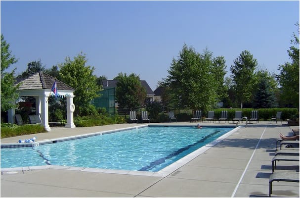 Outdoor pool area with sun loungers and greenery