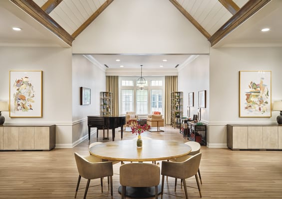Common area with a round table, chairs, and a piano.