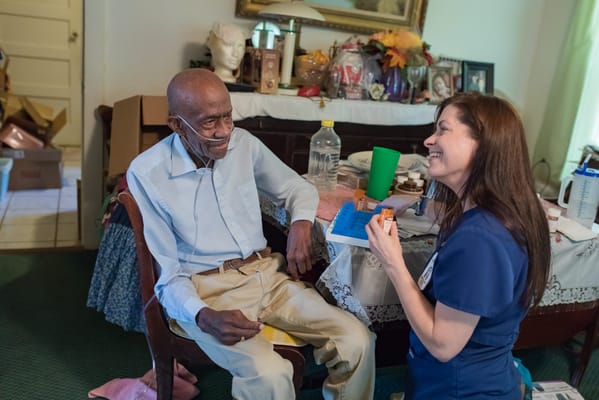 A resident interacting with a caregiver in a cozy room